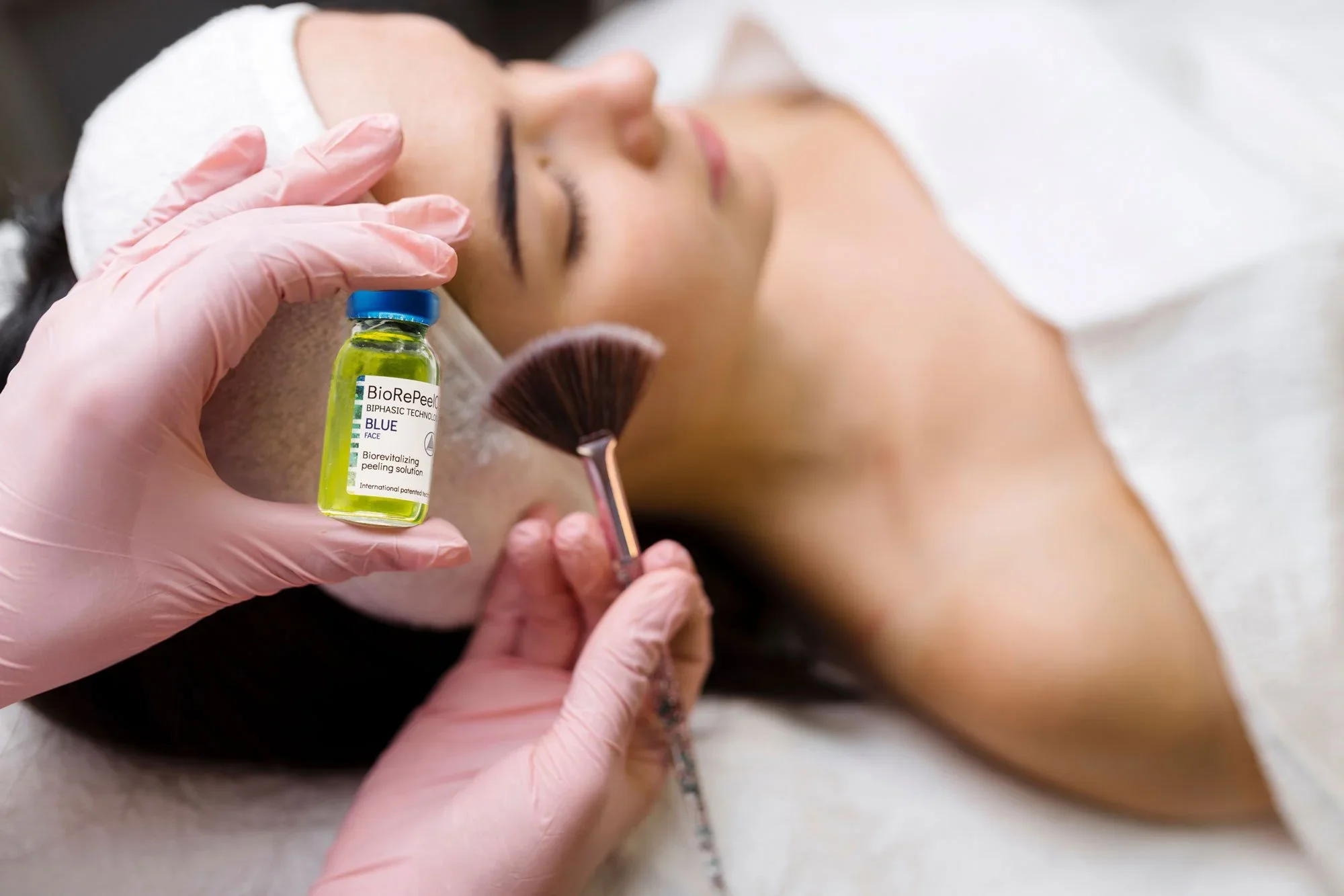 BioRePeel Blue vial shown beside a facial treatment