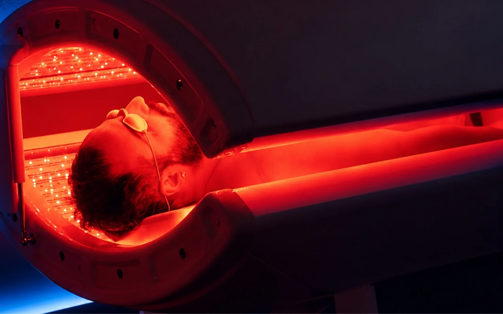 Client in the My BioHealth red light therapy bed, wearing eye protection